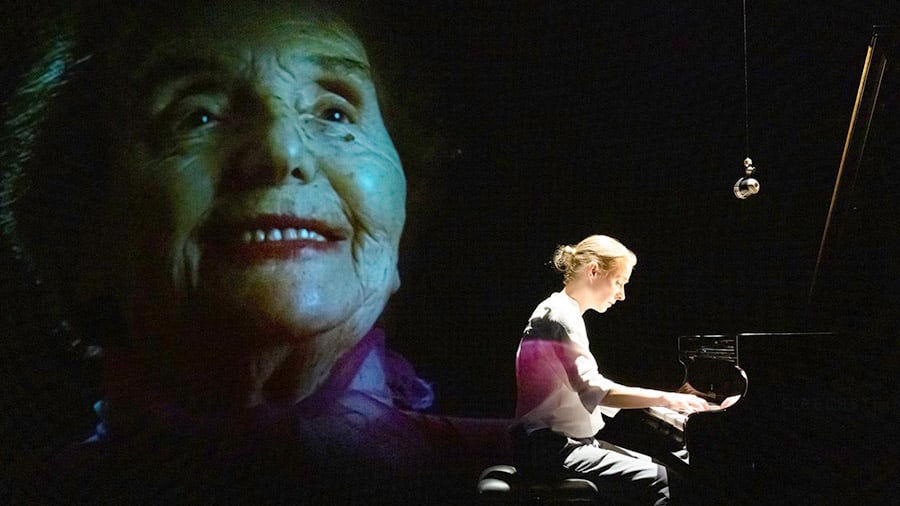 Emotionale Szene mit Nathalie O’Hara am Klavier, umgeben von Videoprojektionen und Soundeffekten