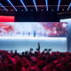 Blick auf die Bühne der SKP-Jahresauftaktshow mit großflächiger Projektion und futuristischem Lichtdesign.