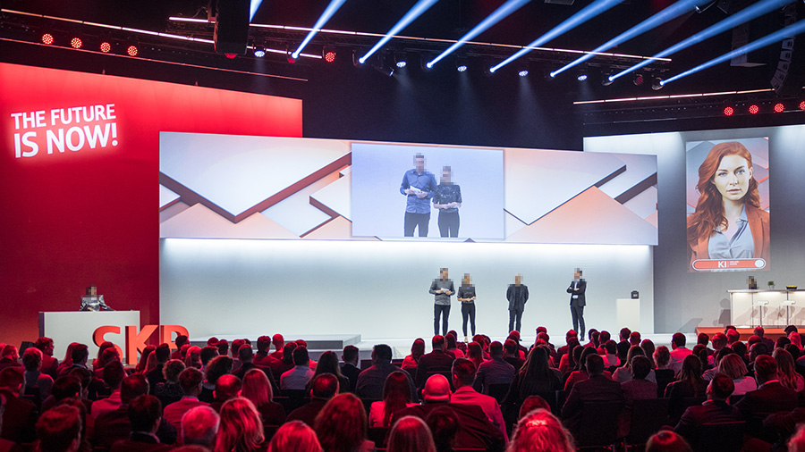Blick auf die Bühne der SKP-Jahresauftaktshow mit großflächiger Projektion und futuristischem Lichtdesign.